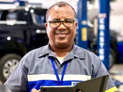 Agendamento de Serviços Ford Forbel Funcionário Ford Forbel uniformizado segurando um caderno