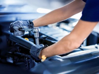 Ford Destaque Serviços Mãos realizando reparo em veículo com ferramenta