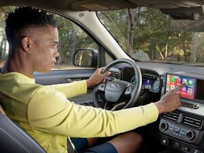 Ford Econorte Agendamento de Test-Drive Homem no banco da frente de veículo Ford mexendo no painel de navegação