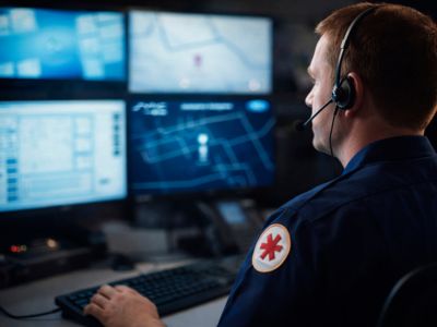 Assistência de Emergência Ortovel Ford Homem usando headset e monitorando quatro telas
