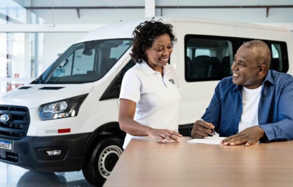 Homem e Mulher fechando negócio na frente de uma Ford Transit