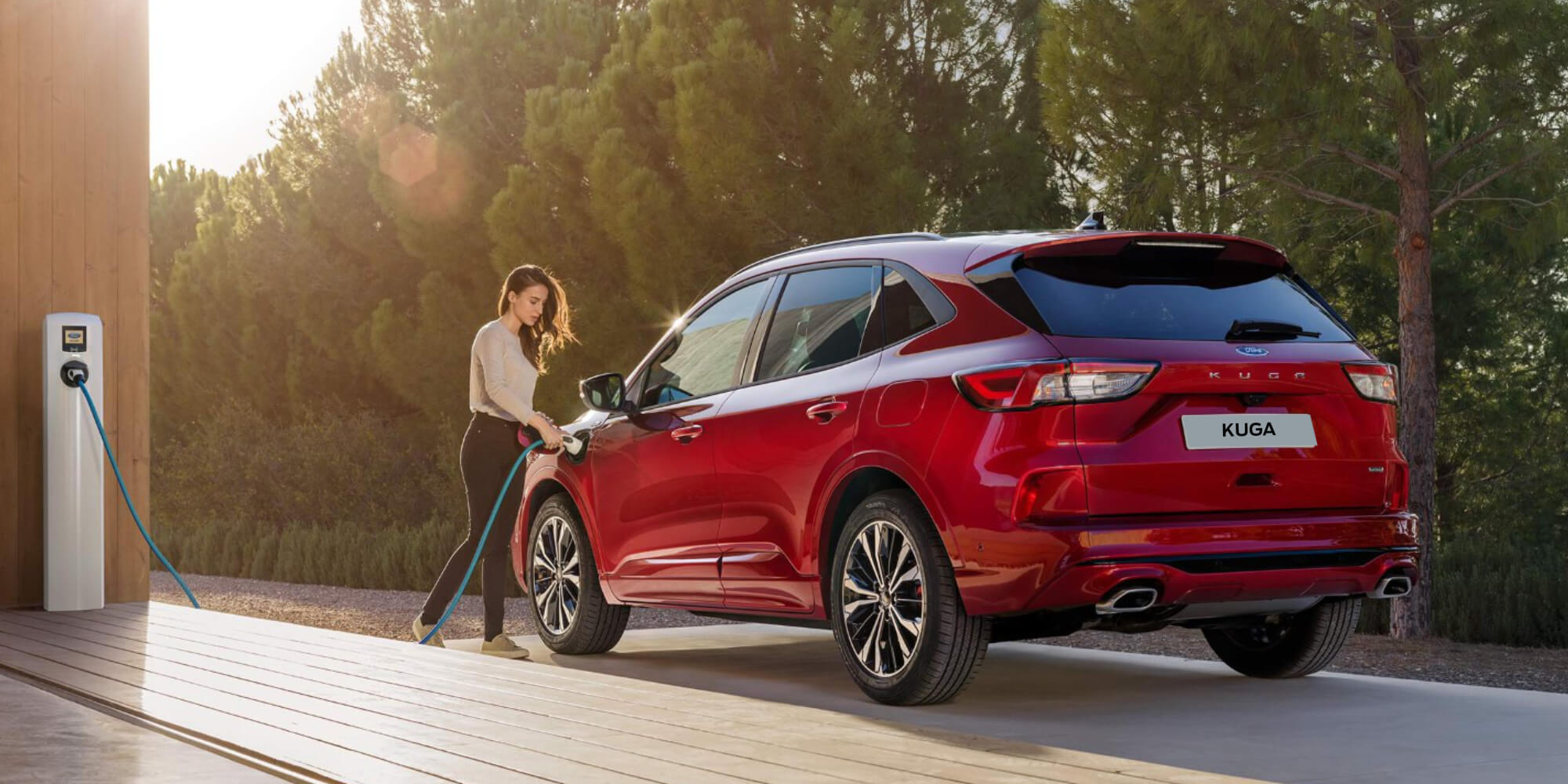 Une femme charge une Ford Kuga Plug-in-Hybrid rouge