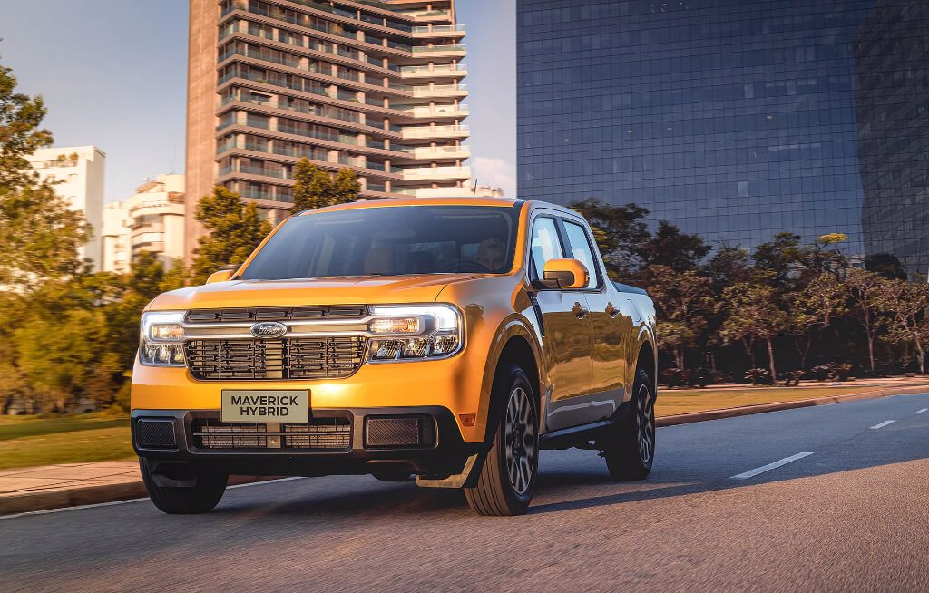 Ford Maverick Hybrid Laranja Rodando em Paisagem Urbana